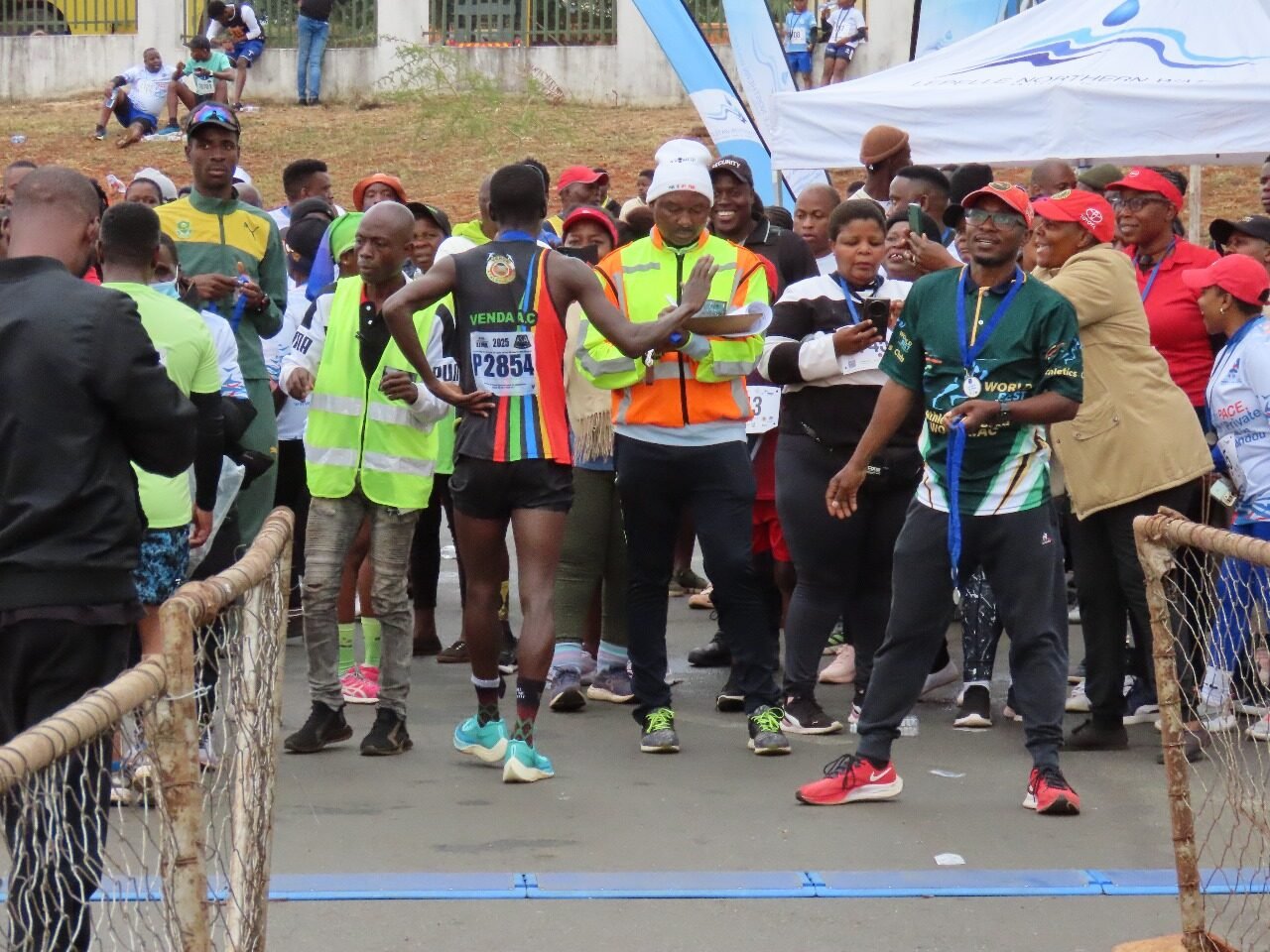 Race official recording a runner's time at the finish line