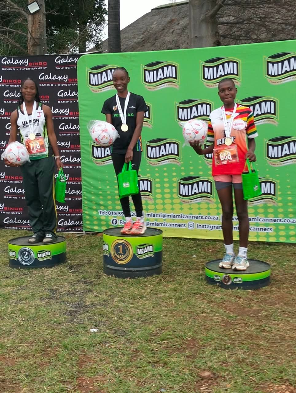 Three young athletes on the podium with their prizes